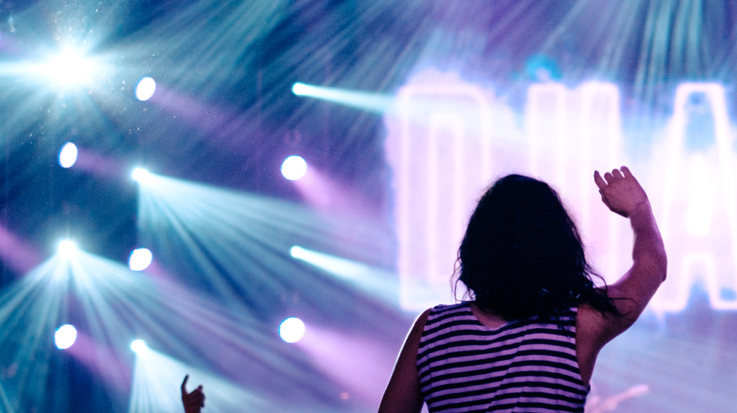 girl with hand in air at concert